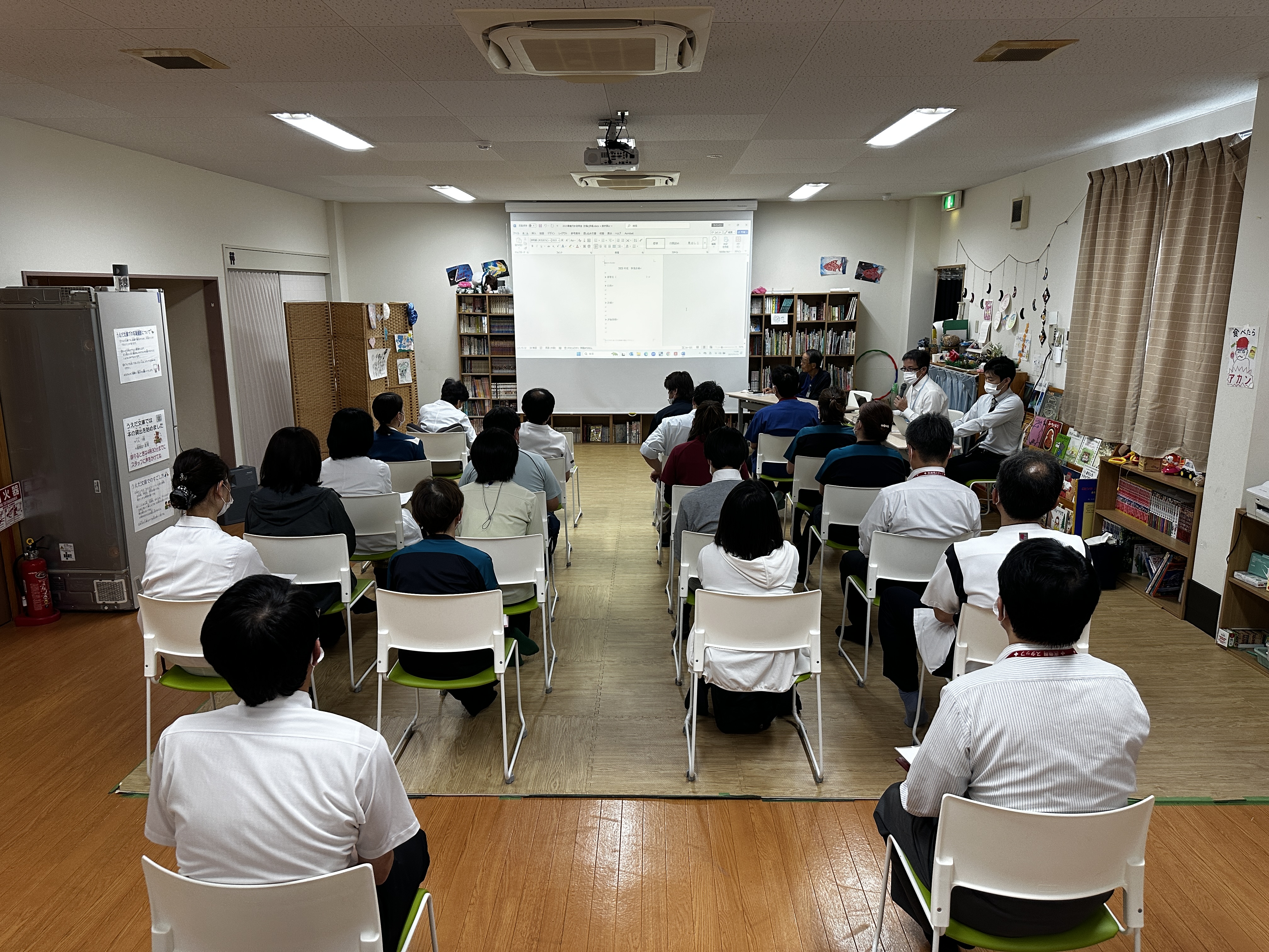 めぶきホールの椅子に座っている健和会の部課長など