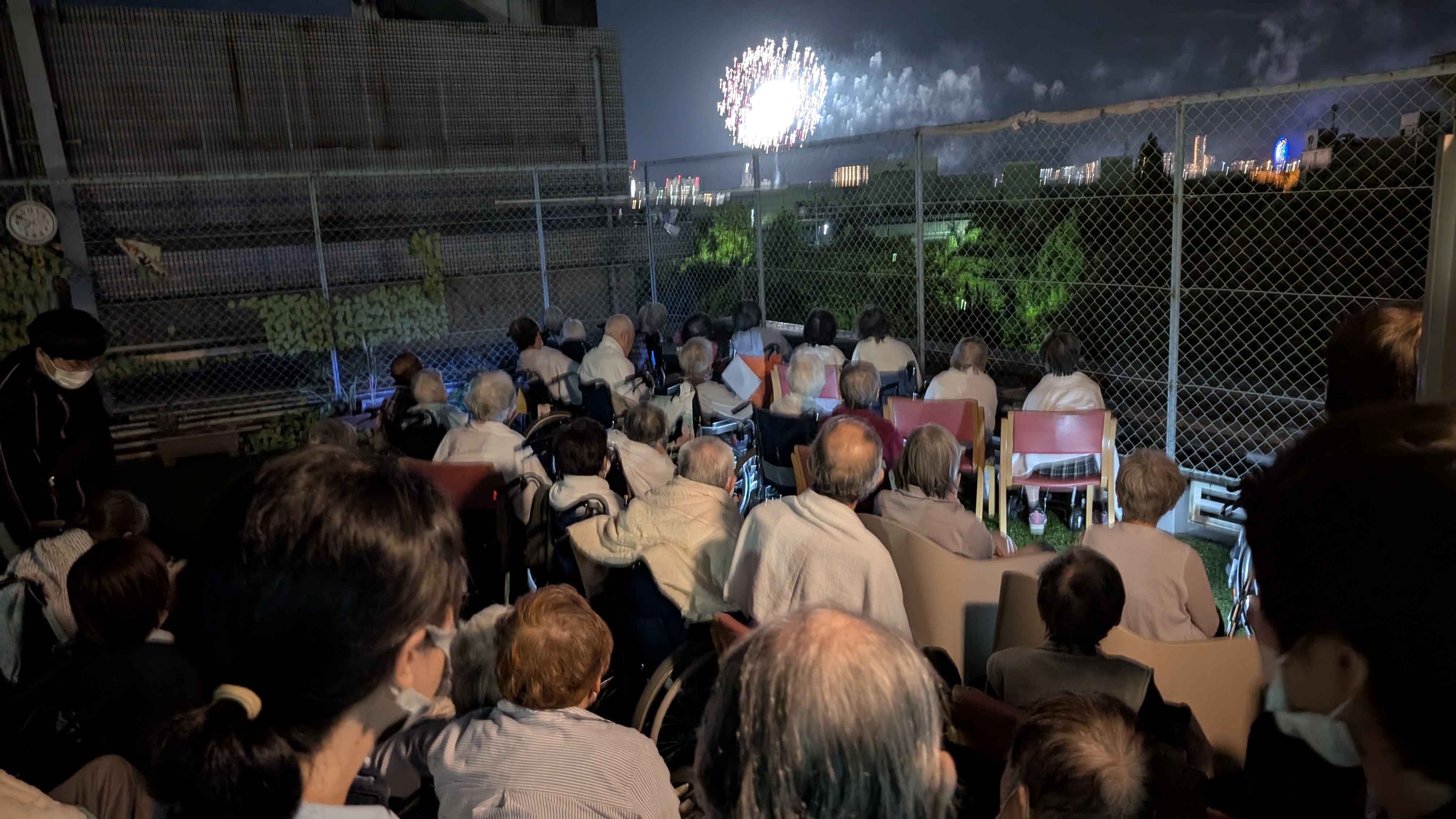 老健利用者さんと職員が一緒に花火を見る様子