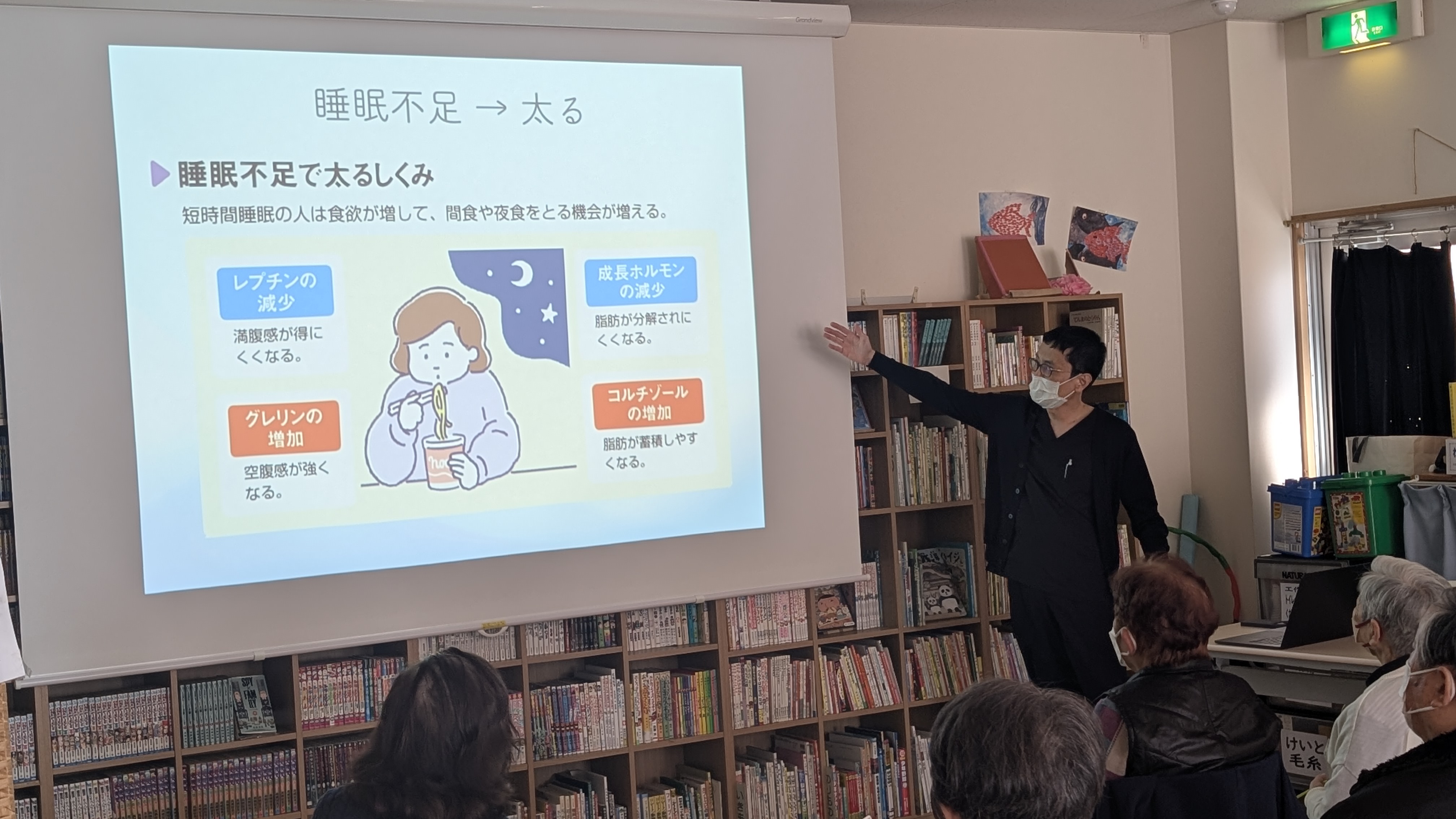 スライドを指さして睡眠の質に関する講義をする耒海医師