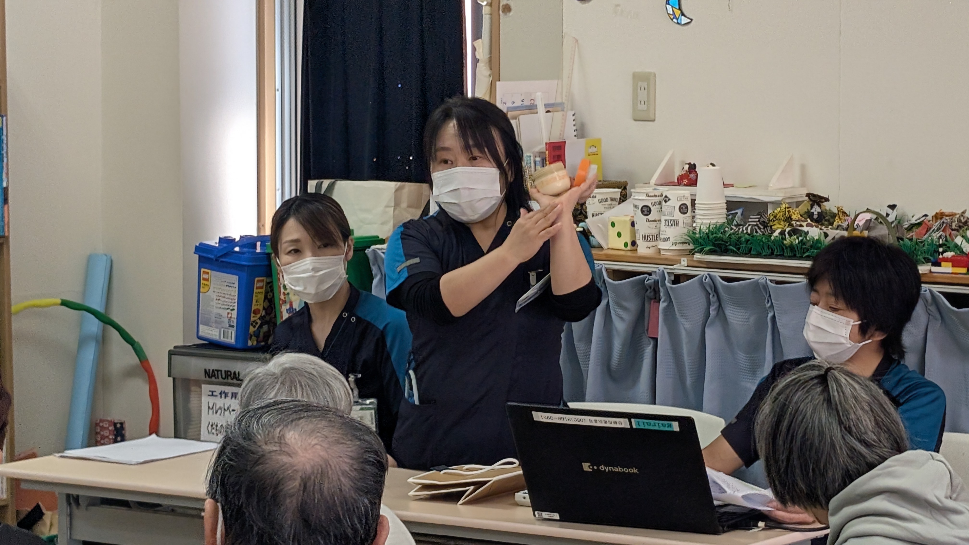 看護師よりスキンケアの方法について、保湿剤を使いながら説明するところ